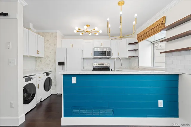 a kitchen with a sink dishwasher and white cabinets with wooden floor