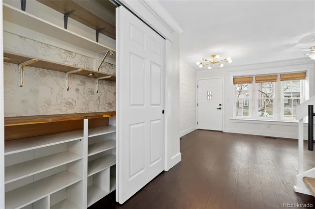 a kitchen with kitchen island granite countertop a stove top oven a refrigerator and a fireplace with wooden floor