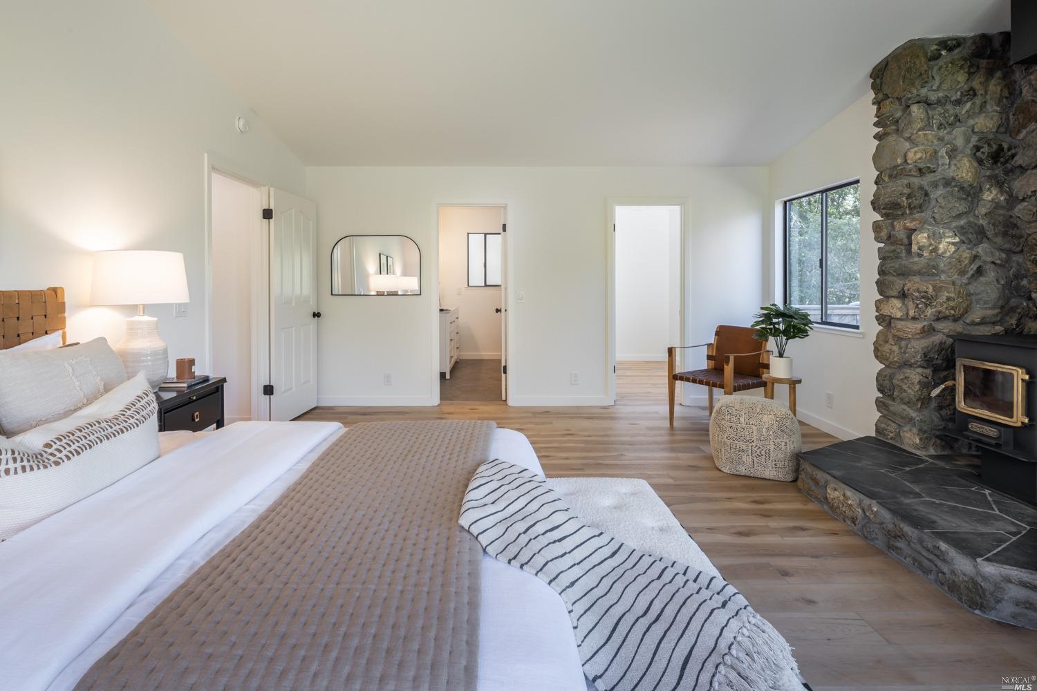 5757 Lucas Valley Road Nicasio, CA 94946 - Photo 17 of 60 a spacious bedroom with a bed a table and wooden floor