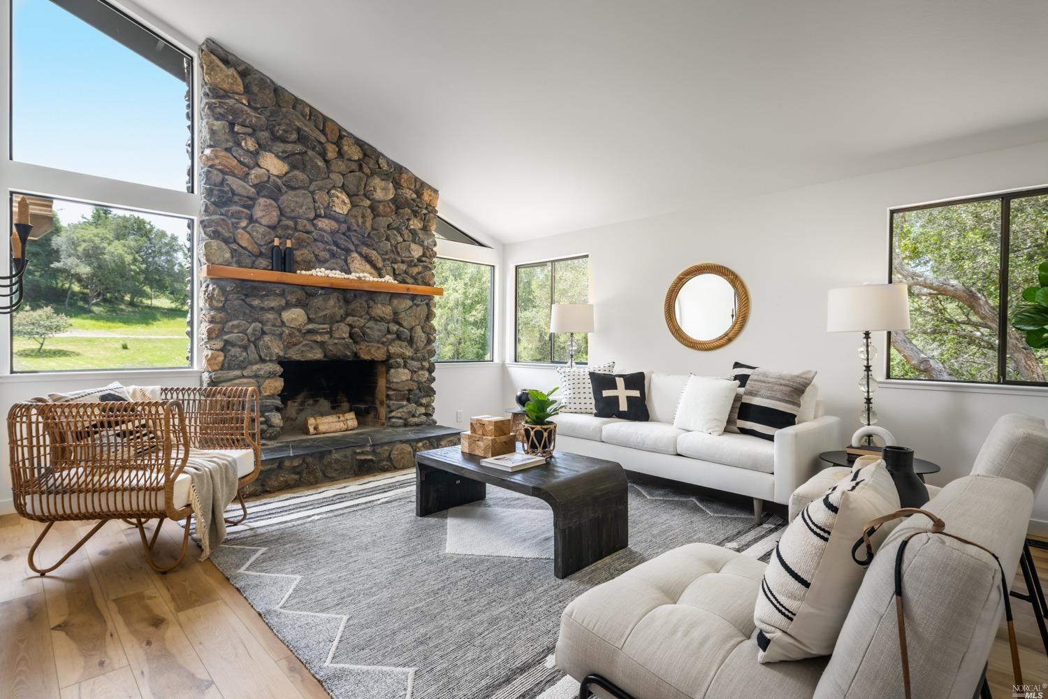 5757 Lucas Valley Road Nicasio, CA 94946 - Photo 7 of 60 a living room with furniture a fireplace and a floor to ceiling window