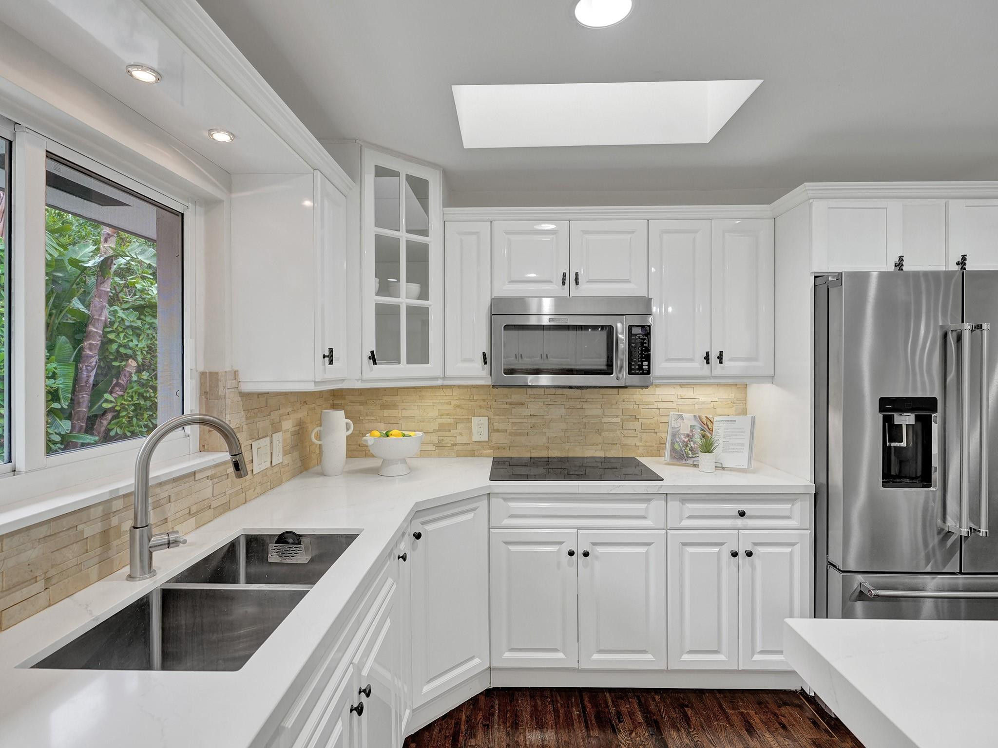2 Minnetonka Road Sea Ranch Lakes, FL 33308 - Photo 18 of 43 a kitchen with kitchen island white cabinets and refrigerator