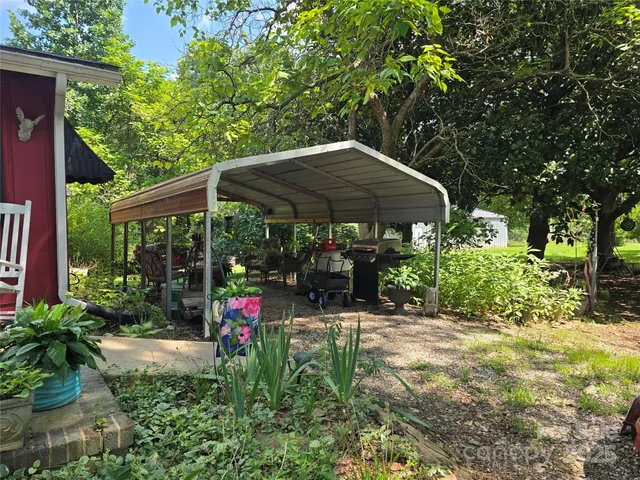 a view of a patio with table and chairs under an umbrella