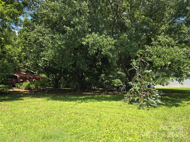 a view of swimming pool with lawn chairs and plants