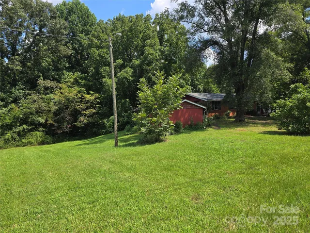 a view of a green field with wooden fence