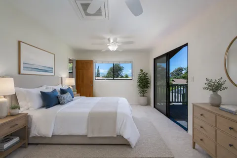a bedroom with a large bed and a chandelier fan
