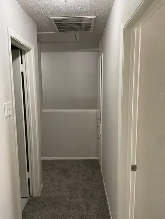 a view of an empty room with chandelier fan