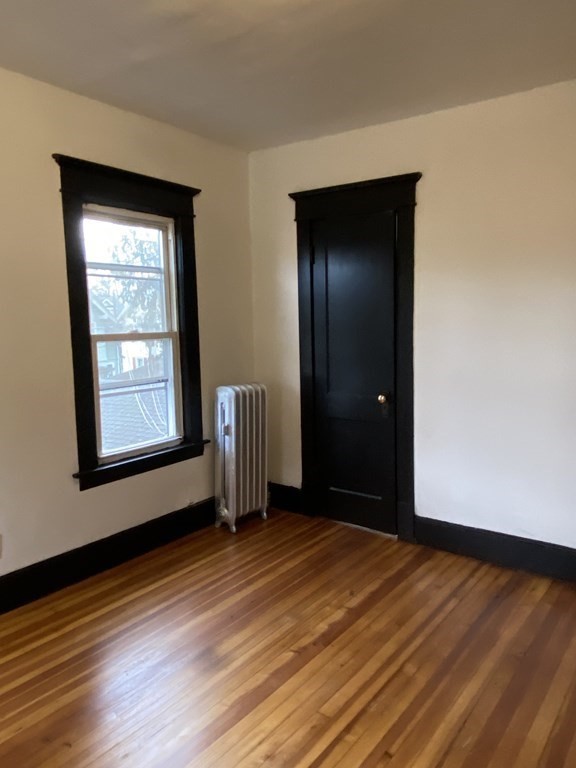 41-43 Lester Street Springfield, MA 01108 - Photo 12 of 25 a view of an empty room with wooden floor and a window