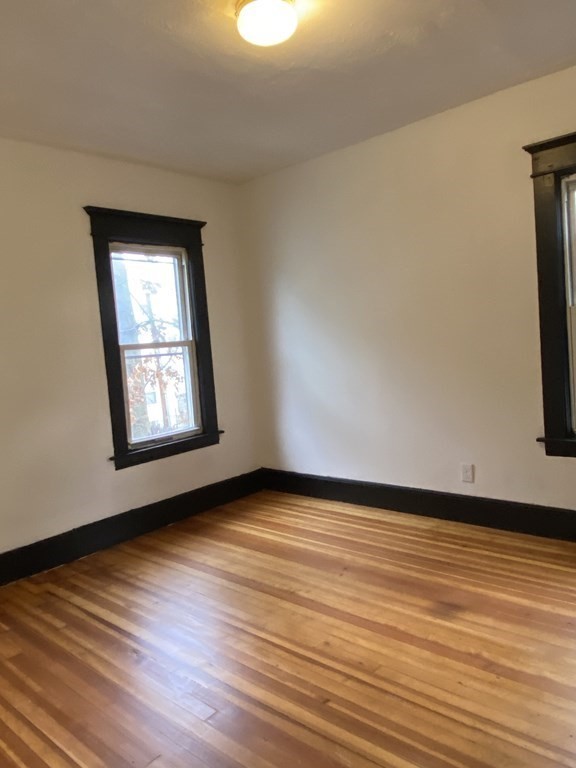 41-43 Lester Street Springfield, MA 01108 - Photo 13 of 25 a view of an empty room with wooden floor and a window