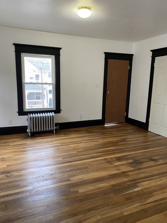 41-43 Lester Street Springfield, MA 01108 - Photo 18 of 25 a view of an empty room with wooden floor and a window