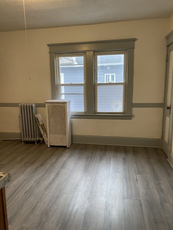 41-43 Lester Street Springfield, MA 01108 - Photo 6 of 25 an empty room with wooden floor and windows