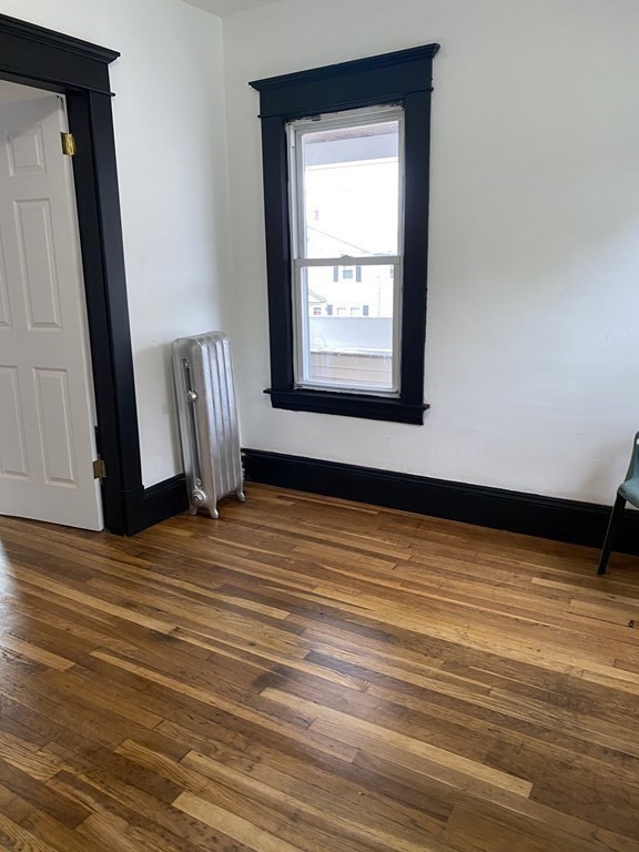 41-43 Lester Street Springfield, MA 01108 - Photo 7 of 25 a view of an empty room with wooden floor and a window