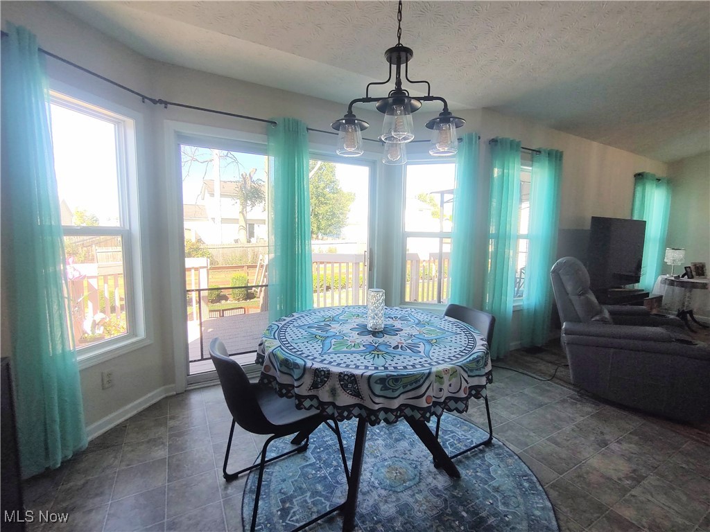 870 Susan Road Ravenna, OH 44266 - Photo 19 of 35 Dining area with a chandelier and a textured ceiling
