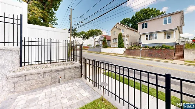 a view of a house with a small yard and wooden fence
