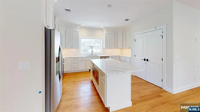 a kitchen with a sink a counter top space stainless steel appliances and cabinets