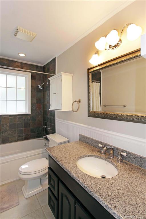 4137 Applegate Road Charlotte, NC 28209 - Photo 19 of 44 a bathroom with a granite countertop sink a toilet a mirror and bathtub