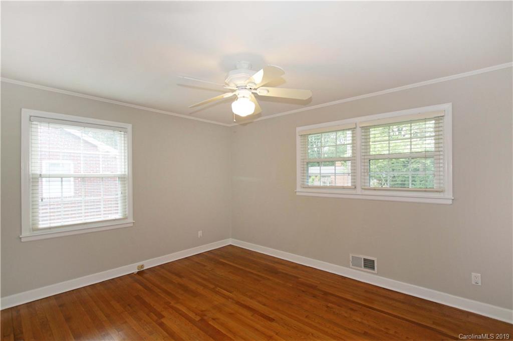 4137 Applegate Road Charlotte, NC 28209 - Photo 22 of 44 a big room with wooden floor a chandelier fan and windows