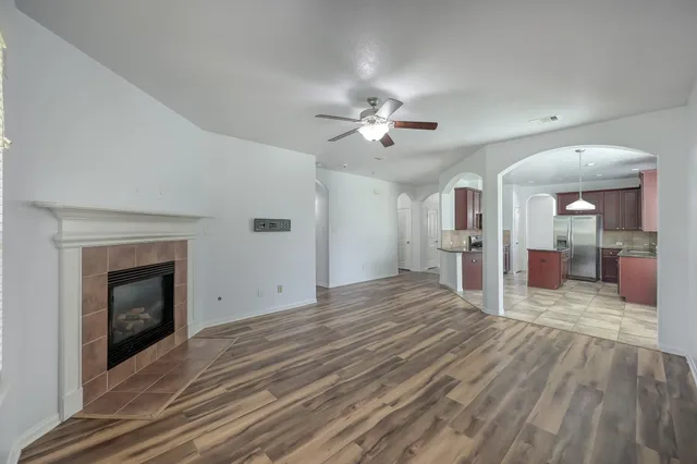 a view of an empty room with a fireplace and a window