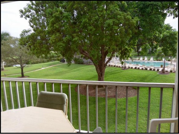 5467 Rattlesnake Hammock Road, Unit 204 Naples, FL 34113 - Photo 1 of 13 a view of a wooden deck and a yard