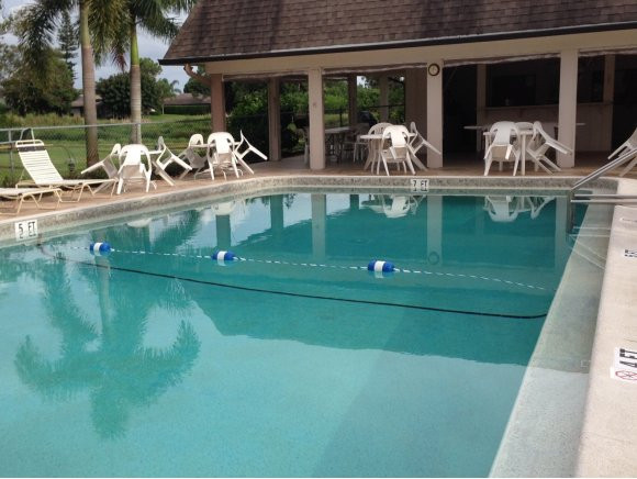 5467 Rattlesnake Hammock Road, Unit 204 Naples, FL 34113 - Photo 3 of 13 a view of a balcony with dining area and chandelier