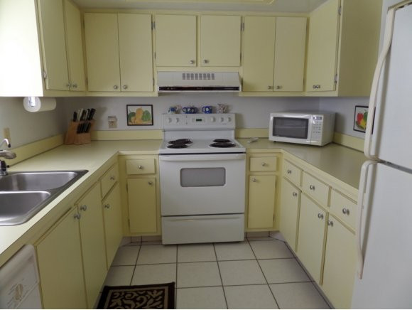 5467 Rattlesnake Hammock Road, Unit 204 Naples, FL 34113 - Photo 4 of 13 a kitchen with cabinets appliances and a sink