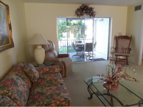 5467 Rattlesnake Hammock Road, Unit 204 Naples, FL 34113 - Photo 5 of 13 a living room with furniture and a large window