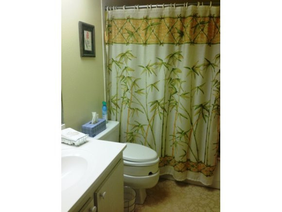 5467 Rattlesnake Hammock Road, Unit 204 Naples, FL 34113 - Photo 9 of 13 a bathroom with a sink a toilet and shower curtain