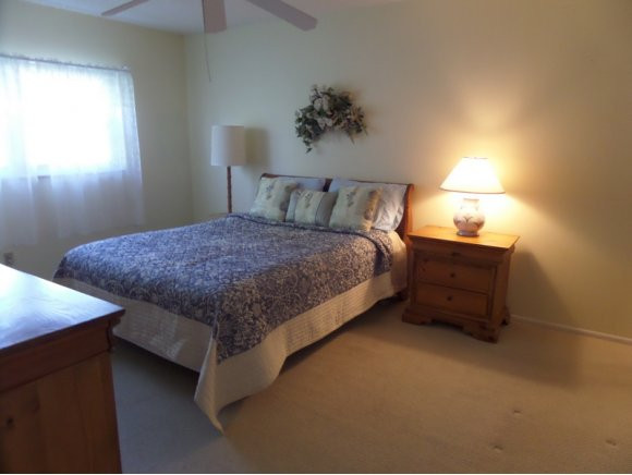 5467 Rattlesnake Hammock Road, Unit 204 Naples, FL 34113 - Photo 10 of 13 a bed sitting in a bedroom next to a lamp