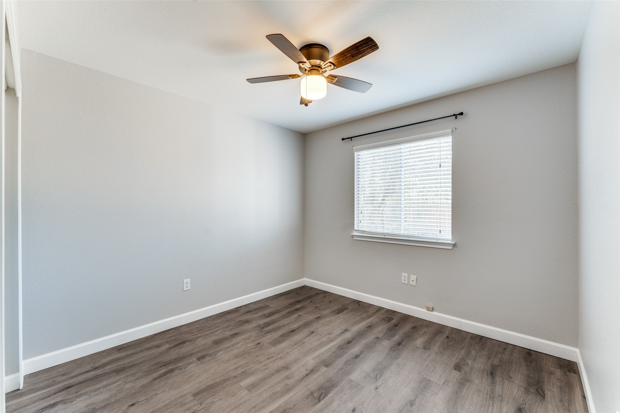 1408 Poppy Seed Lane Austin, TX 78741 - Photo 13 of 23 an empty room with wooden floor and windows
