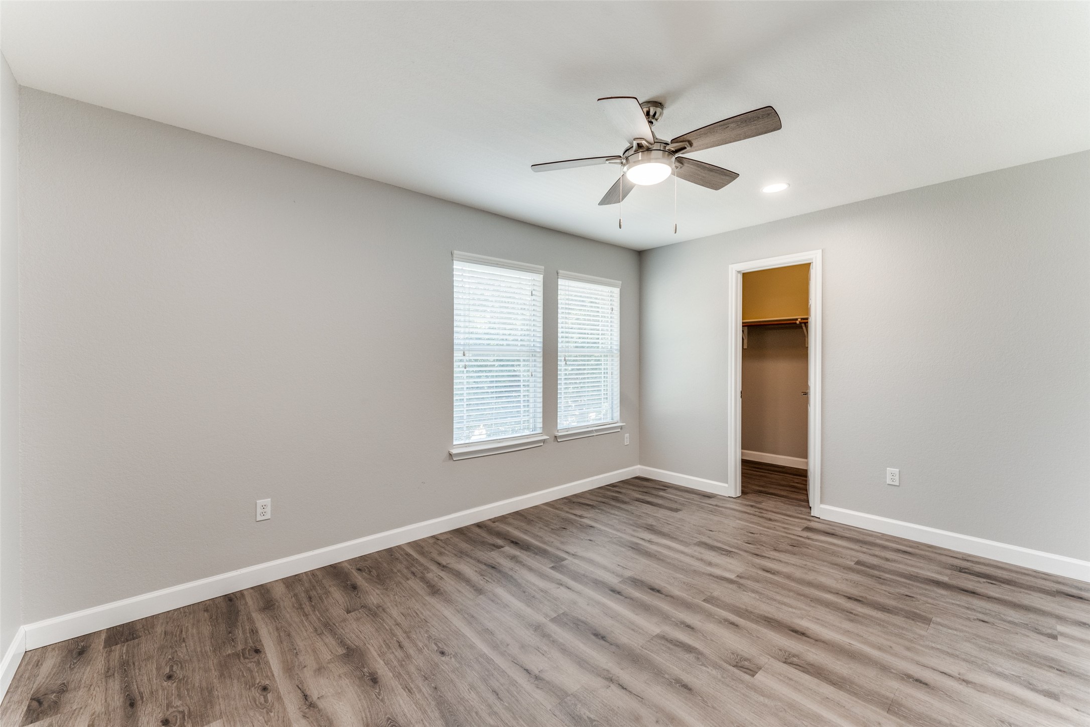 1408 Poppy Seed Lane Austin, TX 78741 - Photo 16 of 23 an empty room with wooden floor fan and windows