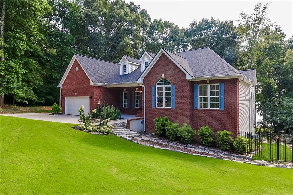 6150 Six Mile Cove Road Cumming, GA 30041 - Photo 1 of 27 a front view of a house with a garden and porch