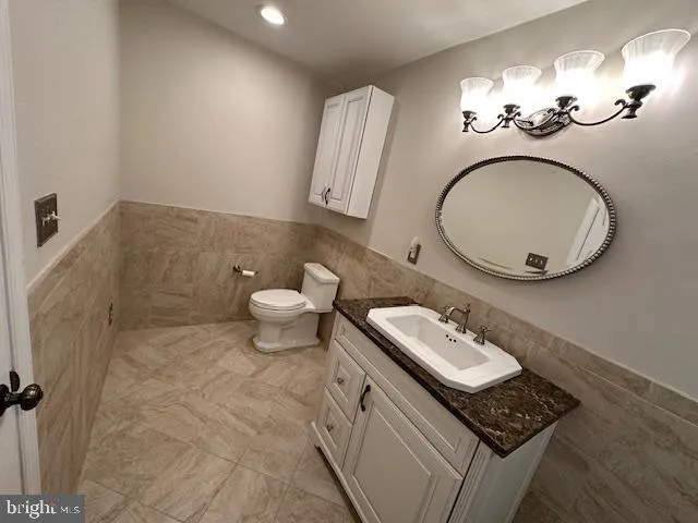 a bathroom with a granite countertop toilet a mirror and sink