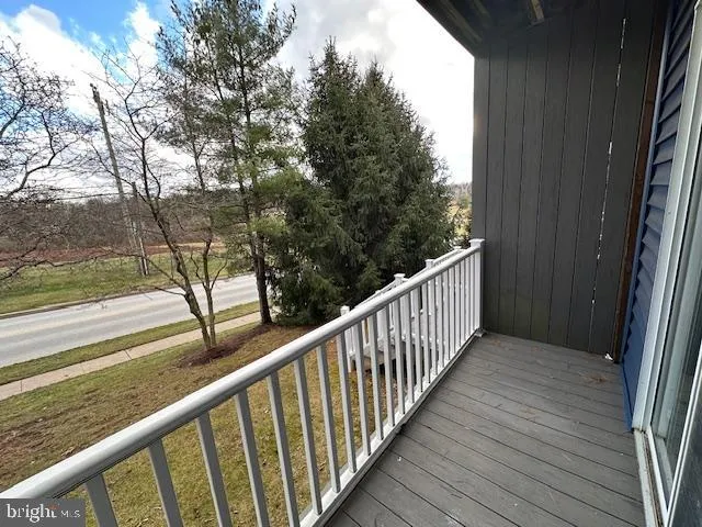 a view of a balcony with wooden floor and fence
