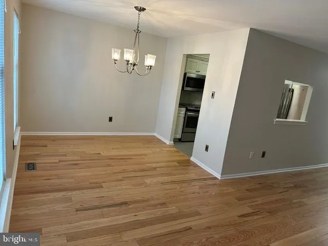 an empty room with wooden floor and ceiling fan