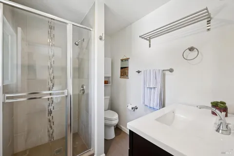 a bathroom with a sink a toilet and shower
