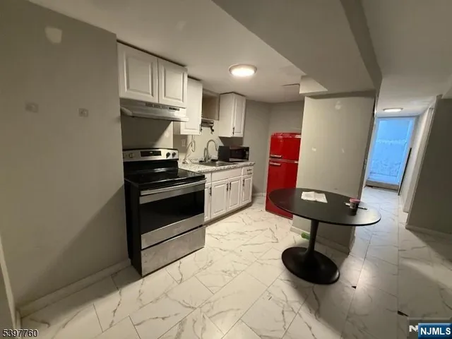 a kitchen with stainless steel appliances granite countertop a stove refrigerator and cabinets