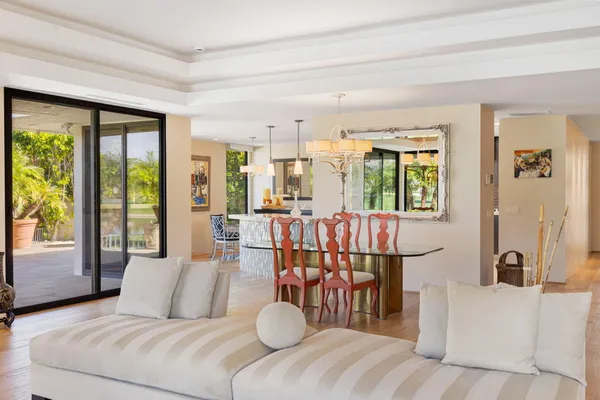 a view of a dining room with furniture a chandelier and wooden floor