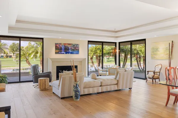 a living room with furniture fireplace and a large window