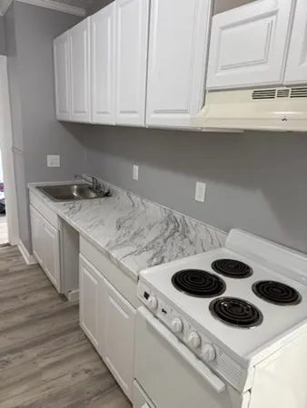 a kitchen with a sink a stove and cabinets