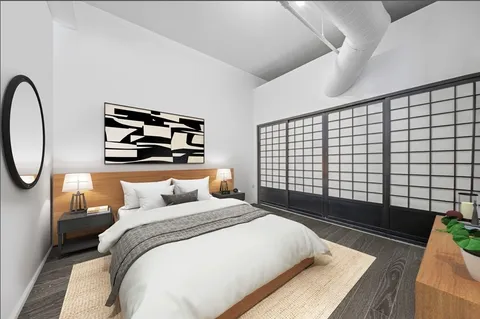 a bedroom with a bed and a painting on the wall