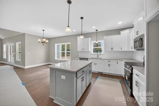 a kitchen with white cabinets and appliances