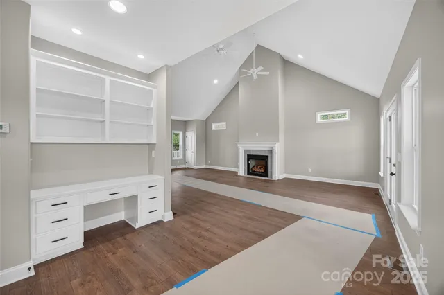 a view of an empty room with a fireplace and a window