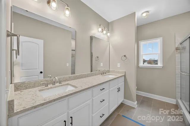 a bathroom with double sink and a mirror