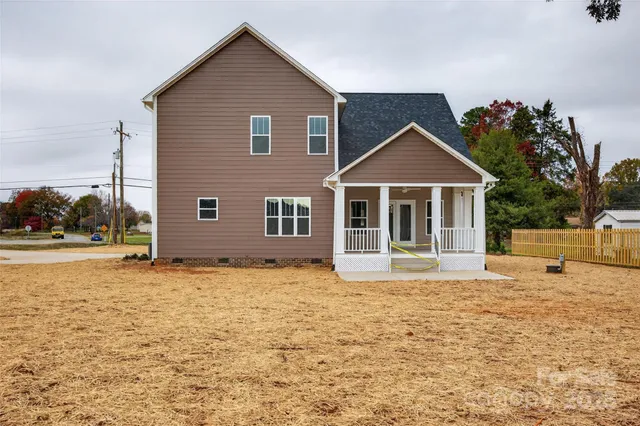 a front view of house with yard and trees in the background