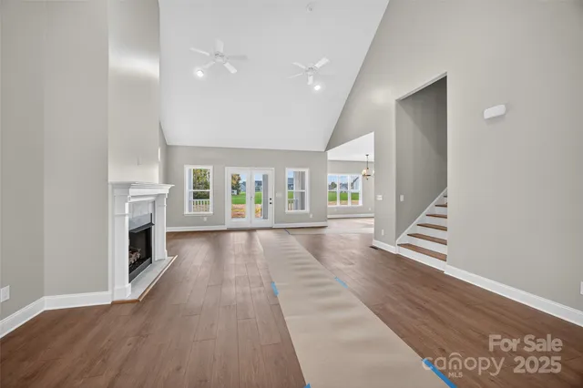 a view of an empty room with fireplace and wooden floor