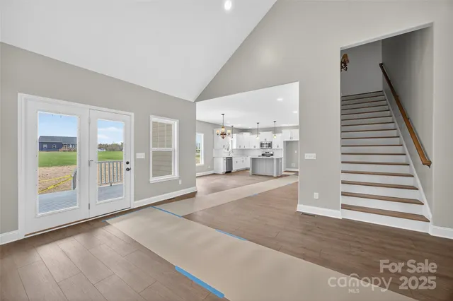 a view of a livingroom with wooden floor and stairs