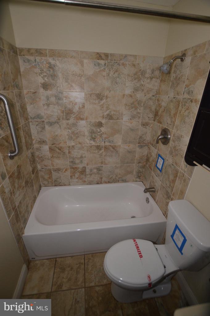 7972 Tick Neck Road Pasadena, MD 21122 - Photo 13 of 19 a bathroom with a toilet and a bath tub
