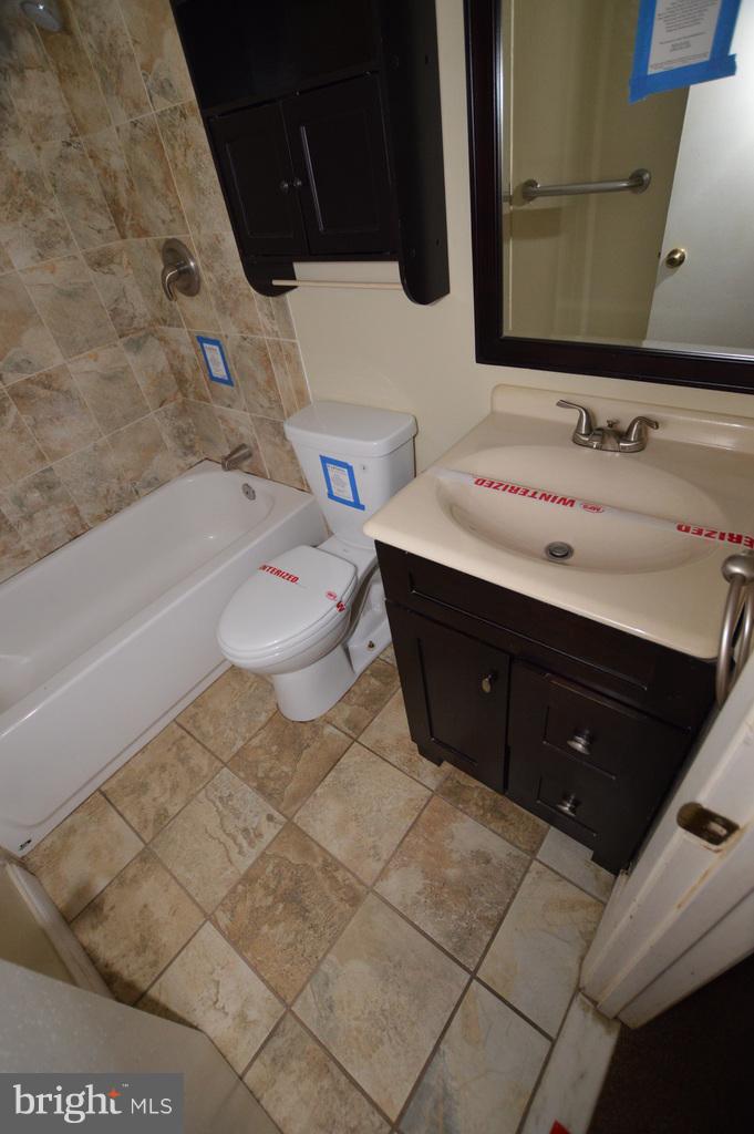 7972 Tick Neck Road Pasadena, MD 21122 - Photo 14 of 19 a bathroom with a sink vanity mirror and toilet