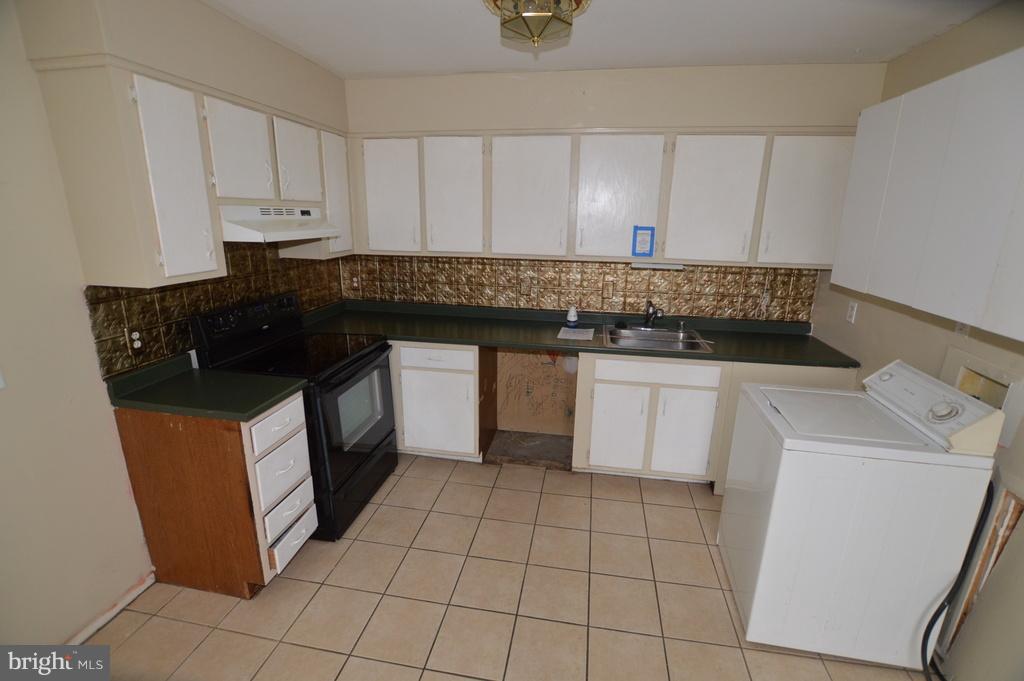 7972 Tick Neck Road Pasadena, MD 21122 - Photo 4 of 19 a kitchen with a sink and cabinets