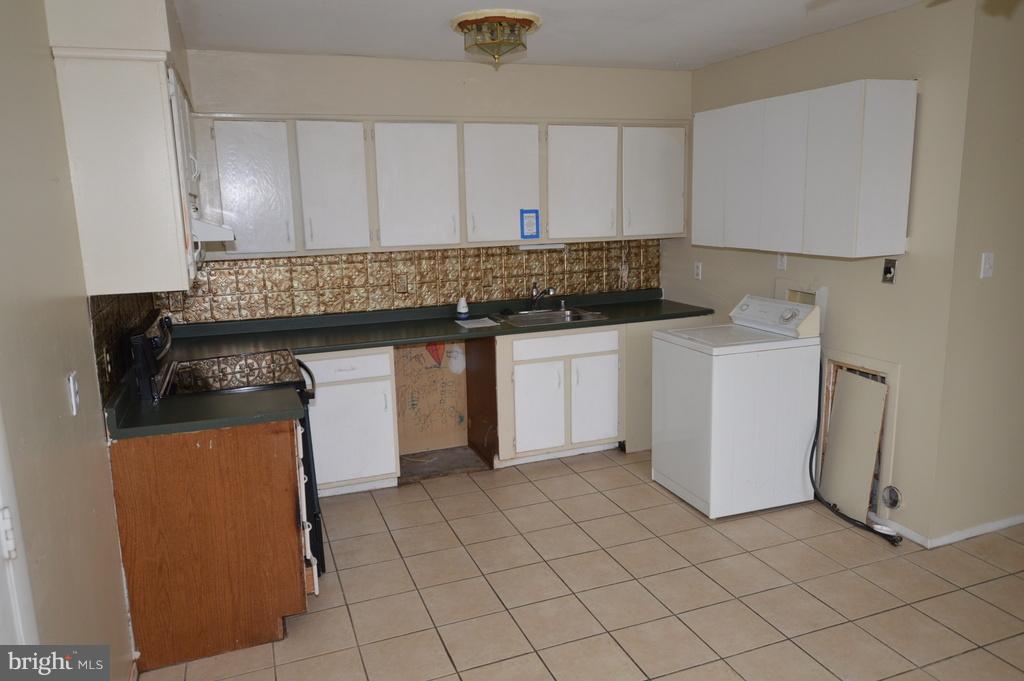 7972 Tick Neck Road Pasadena, MD 21122 - Photo 5 of 19 a kitchen with a sink and cabinets
