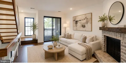 a living room with furniture a fireplace and a large window